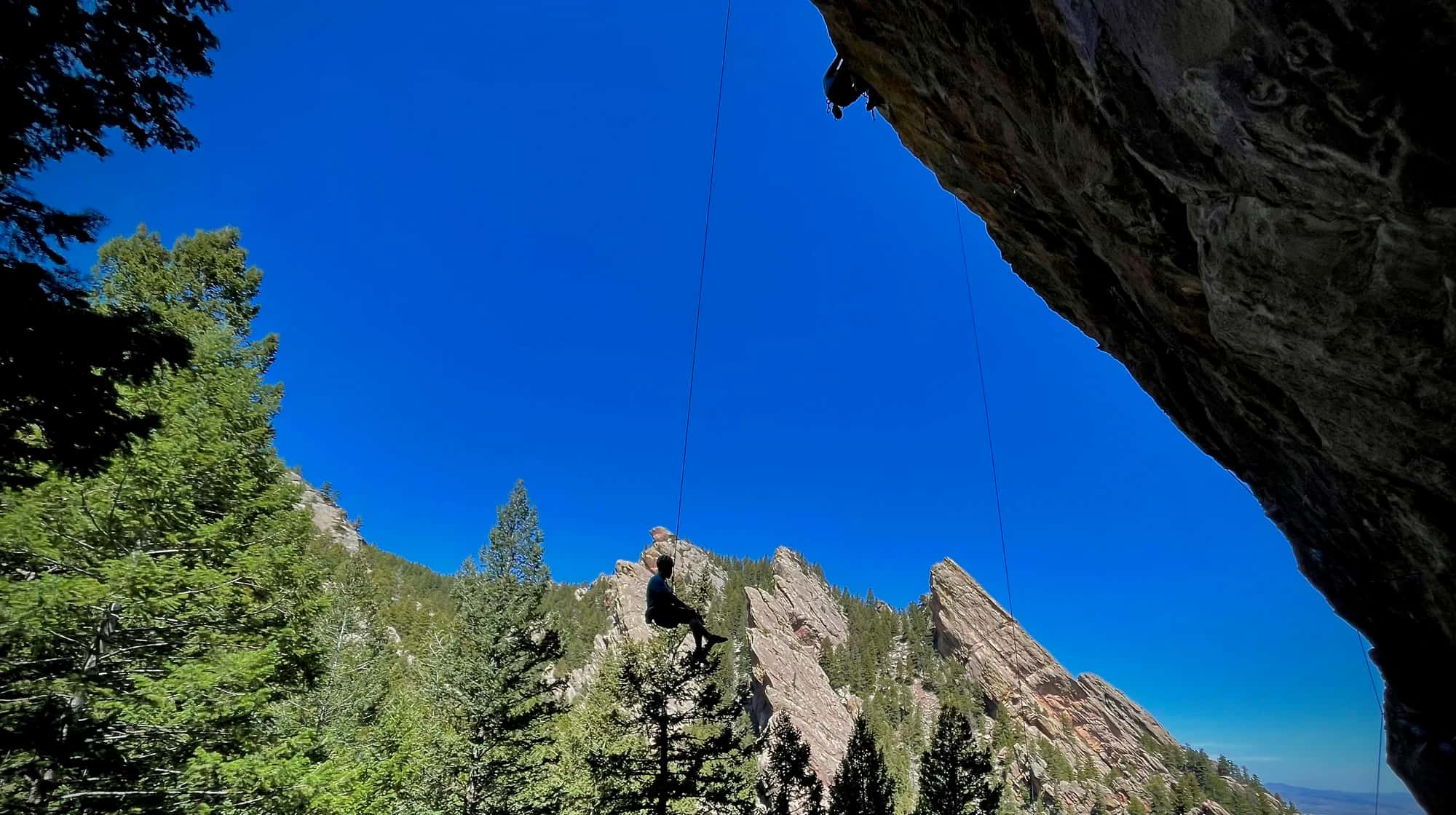 Boulder Flatirons background with rock climber silhouette in foreground